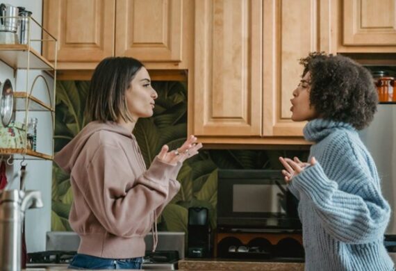 Two females having a conflict in a kitchen