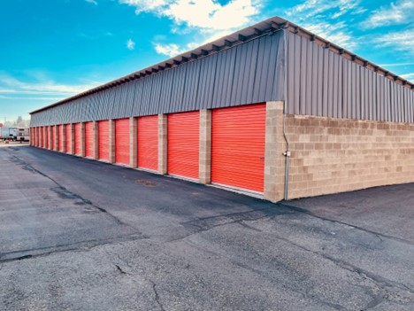 Large-scale storage building with red doors on a clear day