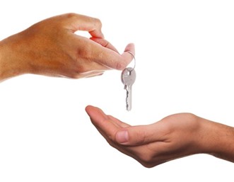 Handing over keys to a new tenant to a new home symbolizes the start of a new lease and the importance of setting competitive rental rates to attract a renter.